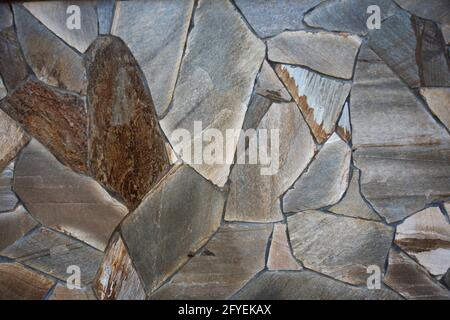 Fotografia di una parete reale in pietra naturale. Parete da giardino con un meraviglioso motivo a mosaico asimmetrico Foto Stock