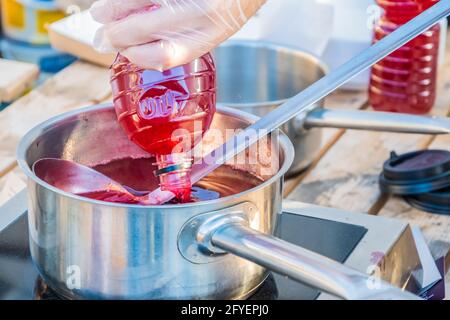 Succo di frutti di bosco a base di fragole fresche o mirtilli rossi: Una bevanda per dissetare la sete viene preparata al banco di un venditore di strada. Festival del cibo in Foto Stock