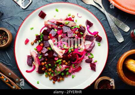 Insalata con aringhe, barbabietole, cipolle e piselli verdi. Insalata russa tradizionale Foto Stock