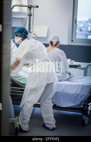 Infermiera nella stanza di un paziente anziano, unità di ricovero Covid della CHU de Limoges. Foto Stock