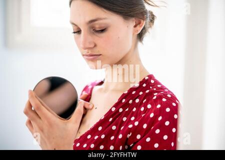 Donna di ispezionare un marchio di bellezza. Foto Stock