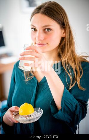 Donna di bere spremuta di succo di limone. Foto Stock