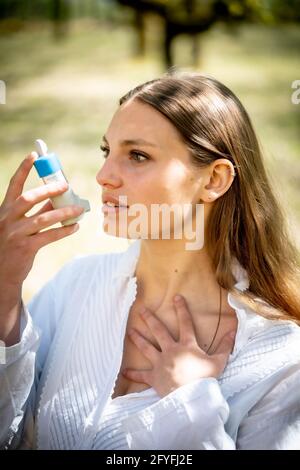 Donna che utilizza un inalatore. Foto Stock