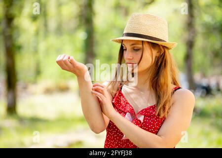 Donna di graffiare il braccio. Foto Stock