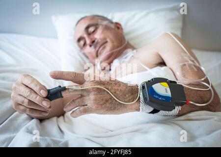 Polisomnografia semplificata a casa, registrazione del livello di saturazione di ossigeno nel sangue (ossimetria notturna) e altri parametri per rilevare la pressione Foto Stock