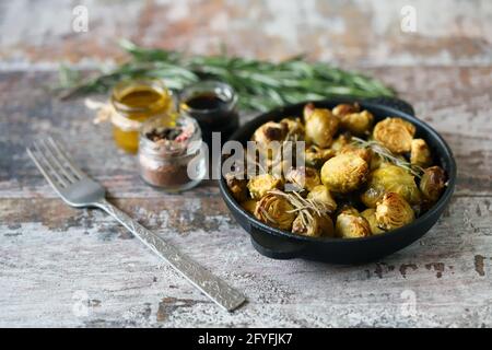 Germogli di Bruxelles al forno con rosmarino e spezie. Foto Stock