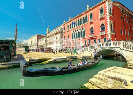 Venezia, Italia - 9 maggio 2021: Piazza San Marco con Palazzo Ducale. Barche in gondola con turisti in tour sui canali di Venezia con maschere chirurgiche per Covid Foto Stock