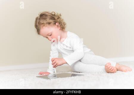 La bambina disegna o gioca sul computer tablet. Foto Stock