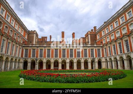 Letto circolare fiorito di tulipani rossi nel giardino del cortile all'Hampton Court Palace, Londra, Inghilterra, UK Foto Stock