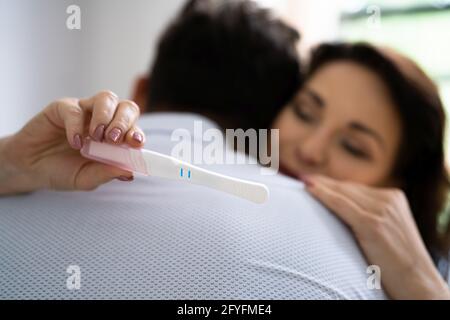 Felice coppia con il test di gravidanza. I genitori sono molto contenti Foto Stock