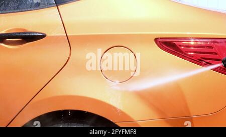 Autolavaggio manuale con acqua pressurizzata in autolavaggio esterno in estate. Foto Stock