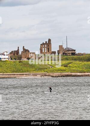 Tynemouth Priorato e stazione di guardia costiera con paddleboarder. Foto Stock