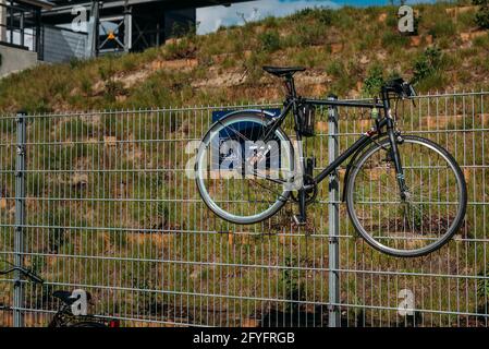 Una bicicletta pende su una recinzione Foto Stock