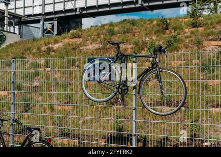 Una bicicletta pende su una recinzione Foto Stock