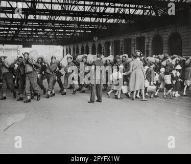 Seconda Guerra Mondiale 1940: Alla stazione ferroviaria di Londra, dove arrivano truppe come bambini che vengono evacuati Foto Stock