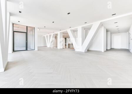 Moderno appartamento attico con pavimento in legno e colonne bianche e senza mobili Foto Stock