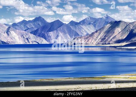 Montagne e Pangong Tso (lago). E 'enorme lago nel territorio unito di Ladakh, India, al confine India Cina si estende Tibet. Foto Stock