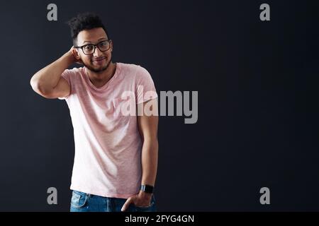 Ops. Siamo spiacenti. Non lo so. Il giovane afro si strugge, mostra un gesto impotente, non sa cosa fare. Sfondo nero con spazio per la copia. Foto Stock