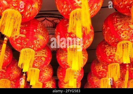 Uno sfondo astratto di lanterne cinesi rosse e dorate appese all'interno di un edificio sullo storico molo di mastice nel area di georgetown di Penang Malays Foto Stock