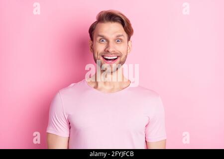 Foto di carino impressionato giovane Signore vestito casual t-shirt grande occhi sorridenti isolati sfondo di colore rosa Foto Stock