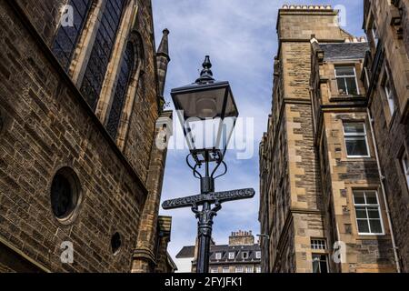 Fotografie di un'antica lampada da strada che reca l'iscrizione Victoria Terrae. La lampada si trova tra due alti edifici in pietra di Edimburgo. Foto Stock
