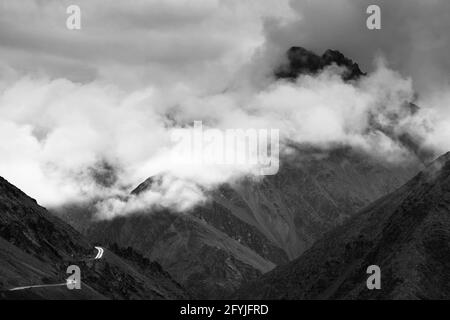 Nuvole sopra l'autostrada del Passo di Zojila, un passo di alta montagna tra Srinagar e Leh a 11575 piedi, 9 km di lunghezza. La più alta Indian National Highway. Nero AN Foto Stock