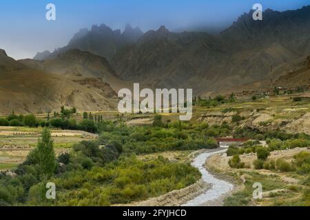 Vista dall'alto del fiume Indus e della valle della città di Kargil con montagne dell'Himalaya e cielo nuvoloso sullo sfondo, passo di Namkila, Ladakh, Jammu e Kashmir, India Foto Stock