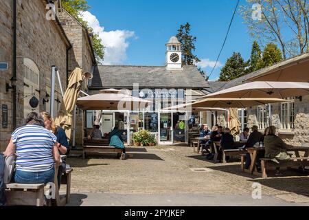 Leonardslee Gardens a West Sussex, Inghilterra, Regno Unito, con persone sedute fuori dal bar in una soleggiata giornata di primavera Foto Stock