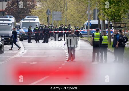 Amburgo, Germania. 28 maggio 2021. La polizia di Riot si trova accanto ai loro veicoli vicino alla scena del crimine cordonato. Un uomo è stato ucciso da ufficiali durante un'operazione di polizia ad Amburgo-Winterhude venerdì. L'uomo sconosciuto aveva precedentemente fermato le auto, le aveva danneggiate e minacciato i conducenti con un coltello, ha detto una portavoce della polizia. Credit: Jonas Walzberg/dpa/Alamy Live News Foto Stock