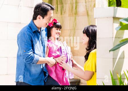 Famiglia cinese invio ragazza a scuola davanti alla loro casa Foto Stock