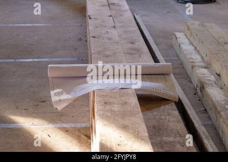 NEW ORLEANS, LA, USA - 9 MAGGIO 2021: I piani architettonici per la ristrutturazione si trovano in cima alle forniture di edifici nel foyer della vecchia residenza Foto Stock