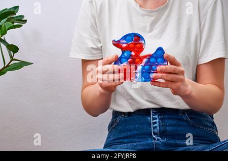 Primo piano ragazza che tiene in mani trendy pop esso giocattolo in forma di un'anatra. Foto Stock