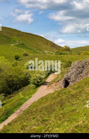 L'ingresso alla grotta di Clutter's Cave nelle colline di Malvern con il campo britannico sullo sfondo, Worcestershire, Inghilterra Foto Stock