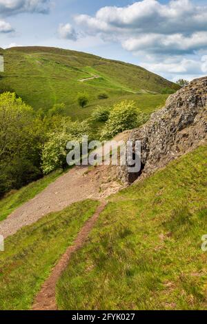 L'ingresso alla grotta di Clutter's Cave nelle colline di Malvern con il campo britannico sullo sfondo, Worcestershire, Inghilterra Foto Stock