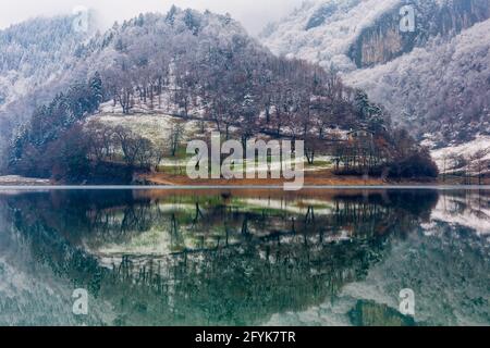 Riflessioni sul lago di montagna del Lago di Tenno, in una fredda giornata nei laghi italiani. Foto Stock