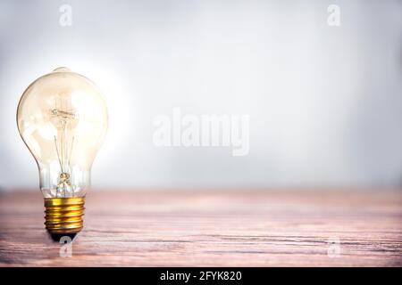 Lampadina che risplende su scaffale di legno con spazio di copia, idea e background creativo di concetto, dea e Creative Concept per startup nuovo progetto. Tecnologia Foto Stock
