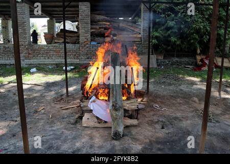 27 maggio 2021: Una pira di una vittima di Covid-19 di 22 anni brucia in un terreno di cremazione a Srinagar, indiano somministrato Kashmir il 27 maggio 2021. L'India ha riportato 211553 nuovi casi di covid-19 e 3842 decessi nelle ultime 24 ore. Credit: Muzamil Mattoo/IMAGESLIVE/ZUMA Wire/Alamy Live News Foto Stock