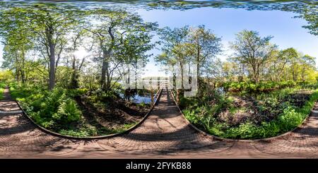 Visualizzazione panoramica a 360 gradi di Panorama sferico completo senza giunture angolo di 360 gradi del percorso attraverso il bosco per raggiungere la scena su Filby Broad nel Norfolk Broads Nat