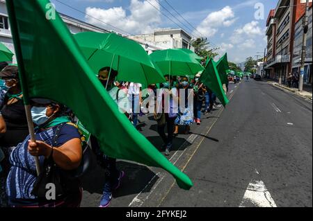 San Salvador, El Salvador. 28 maggio 2021. I manifestanti marciavano con bandiere e ombrelli durante la dimostrazione.le donne e i movimenti femministi Salvadorani hanno marciato al Congresso nella Giornata Internazionale d'azione per la Salute delle Donne protestando contro un aumento delle femminicidi, donne scomparse e l'archiviazione delle leggi che avrebbero giovato alle donne e alla comunità LGBT. (Foto di Camilo Freedman/SOPA Images/Sipa USA) Credit: Sipa USA/Alamy Live News Foto Stock
