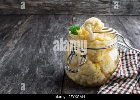 Cavolfiore sottaceto in vaso di vetro su rustico tavolo di legno Foto Stock