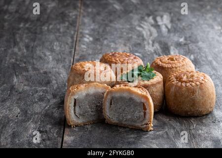 Mini torte di maiale Melton Mowbray su rustico tavolo di legno Foto Stock