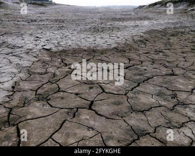 Il fiume si sta asciugando. Dettaglio di terreno incrinato o terra dopo la siccità tempo. Terra incrinata, terreno incrinato. Texture di terreno cracking asciutto parcheggio terra Foto Stock