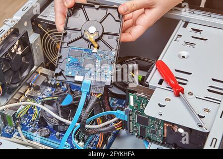 Rimozione del disco rigido del computer dall'unità di sistema per sostituirlo con uno nuovo. Foto Stock