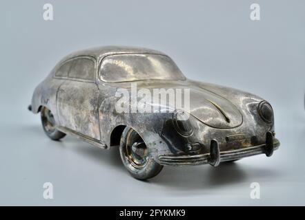 Modello in scala giocattolo vintage color argento intarsionato di una Porsche 356 in studio girato su sfondo bianco Foto Stock