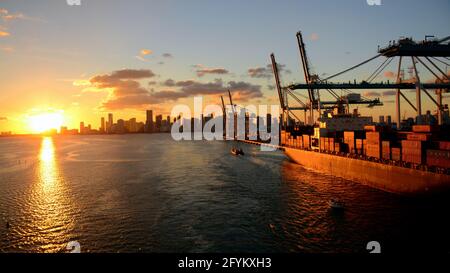 USA; TRAMONTO SU MIAMI, FLORIDA; NAVE DA CARICO NEL PORTO DI MIAMI; VISTA CANALE DEI PESCATORI, DODGE ISLAND Foto Stock