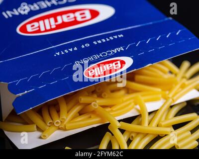 NEUWIED, GERMANIA - 22 maggio 2021: Neuwied, Germania - 22 maggio 2021: Dettagli di una confezione di pasta Barilla con maccheroni riversati su fondo scuro Foto Stock