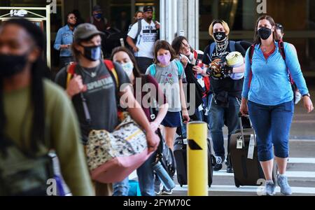 Orlando, Stati Uniti. 28 maggio 2021. I viaggiatori che indossano maschere protettive arrivano all'aeroporto internazionale di Orlando il venerdì prima del Memorial Day. Dal momento che sempre più persone hanno ricevuto il vaccino COVID-19, l'American Automobile Association (AAA) prevede che oltre 37 milioni di americani percorreranno più di 50 miglia questo fine settimana del Memorial Day, molti per la prima volta dall'inizio della pandemia. (Foto di Paul Hennessy/SOPA Images/Sipa USA) Credit: Sipa USA/Alamy Live News Foto Stock