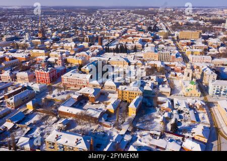 Vista panoramica aerea delle case innevate e delle chiese della città russa di Yelet nella soleggiata giornata invernale, Lipetsk Oblast Foto Stock