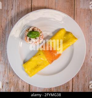 Omelette con salmone e pomodori, servita su piatto, piatto tradizionale norvegese Foto Stock