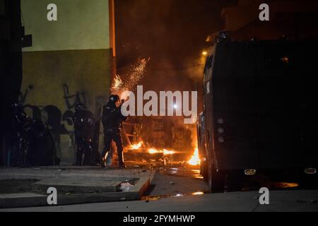 Passo, Narino, Colombia. 28 maggio 2021. Un poliziotto antisommossa spara un barattolo di gas lacrimogeni mentre i carri armati della polizia colombiana (ESMAD) rispondono agli scontri con i dimostranti, mentre la Colombia segna il suo primo mese di proteste anti-governative contro la legge fiscale e le riforme sanitarie del presidente Duque, nonché la brutalità e i disordini della polizia, Migliaia di persone inondano le strade di Pato, Narino, Colombia, il 28 maggio 2021. Credit: Camilo Erasso/LongVisual/ZUMA Wire/Alamy Live News Foto Stock